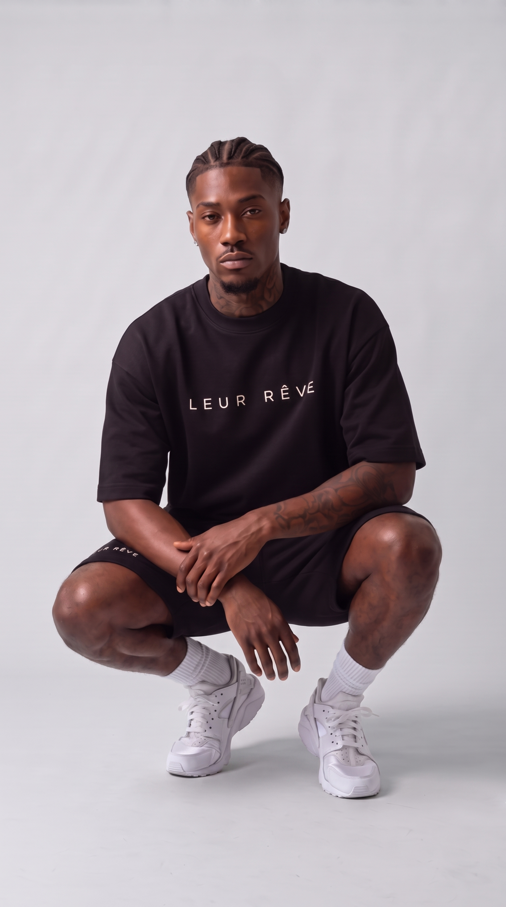 Man wearing the Leur Rêve Set in black, crouching
