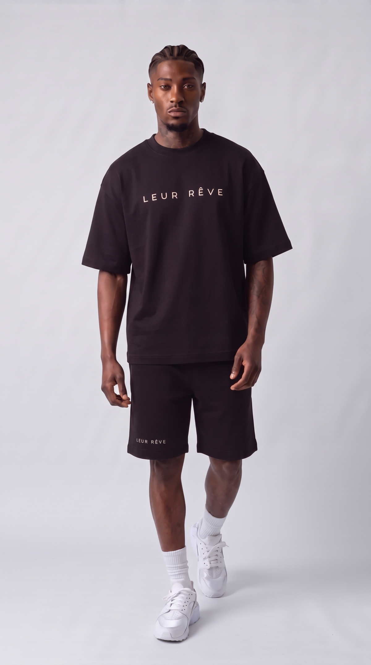 Man wearing the Leur Rêve Set in black, walking, front view