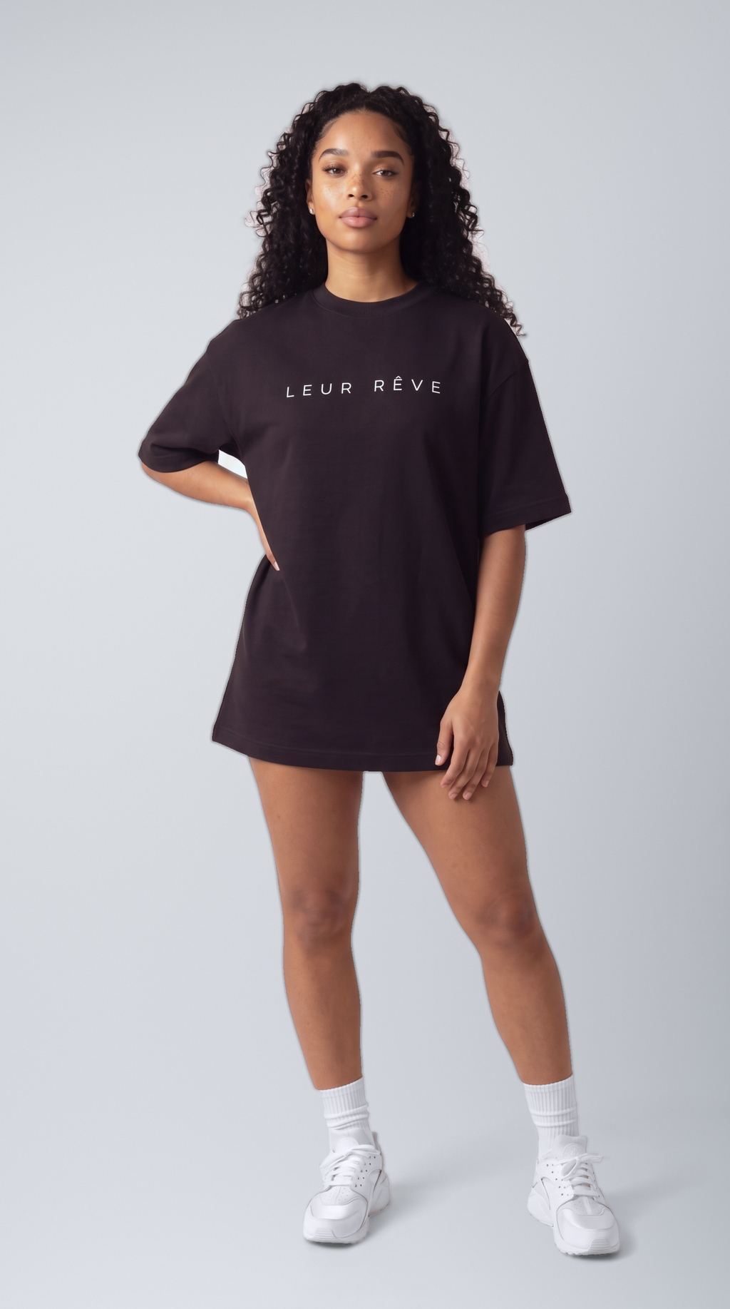 Woman wearing the Leur Rêve Tee in black, hand on hip