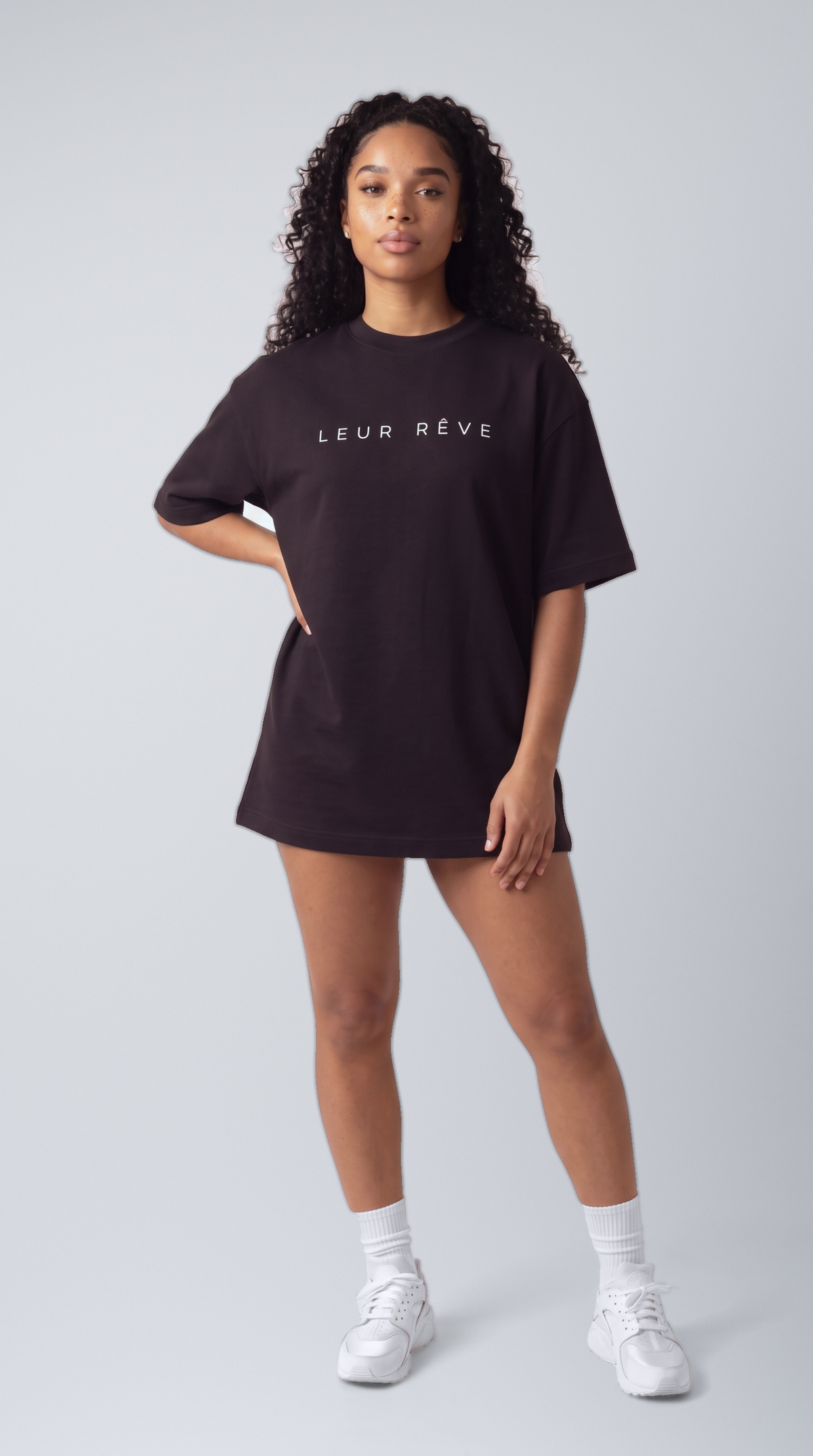 Woman wearing the Leur Rêve Tee in black, hand on hip